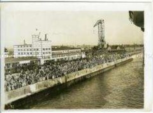 Menschenmenge vor dem Abfertigungsgebäude des Norddeutschen Lloyd verabschieden den Hochseepassagierdampfer "Bremen" zu seiner ersten Fahrt (Jungfernfahrt)