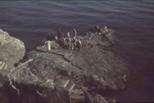 Reisefotos. Gruppe von Touristen auf einem Felsen im Meer
