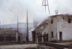 Grenzsoldaten bewachen den Feuerwehreinsatz an der Grenzmauer in der Schwedter Straße
