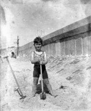 Junge mit Spaten am Strand