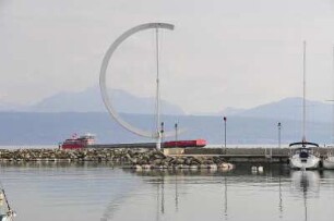 Lausanne - Hafen Ouchy : Hinter der Hafenmole fährt auf dem Genfer See ein Frachtschiff mit Schweizer Flagge. Aufgenommen in Lausanne am 18. Mai 2010