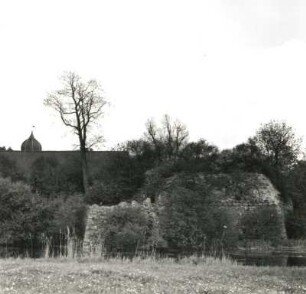 Spantekow. Bruchsteinmauer des alten Festungsbaus. Ansicht mit Schlossbau über den Wassergraben