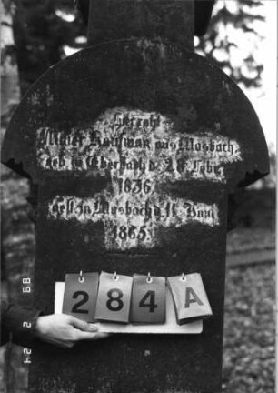 Grabstein 284 (Index: 99752236) Material: Sandstein Zustand: vorne komplett verwittert, beschädigt Maße HxBxT: 215x69x44 cm Beschreibung: ädikulaart. St. m. Säulen, ausgezog. Rundbogenabschl. , rechteck. erhöht, getreppt. Sockel Symbolik: Sternenfries, Ranken: Grabstein 284A