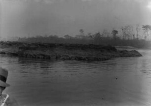Flussinsel im Rio Grande : Eine Flussinsel im Lauf des Rio Grande von einem Boot aus. Links im Bild ein Mann mit einem Hut, im Hintergrund das Ufer mit Bäumen.