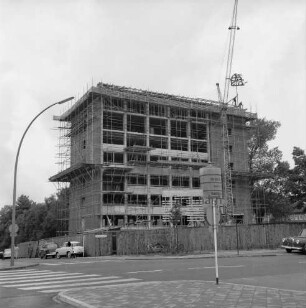Erweiterungsbau "Hochhaus" [später Gebäude B]: III. Bauabschnitt: Richtfest am 2. Juli 1962: Blick auf das Gebäude Ecke Bangertstraße / Mommsenstraße: links davor Baukran: links Straßenlampe und parkende Pkws