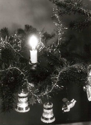 Weihnachtsbaumzweig mit Kerze, zwei Glasglocken, hölzernem Stern und Hängeengel mit Blasinstrument (1901/1925; Wendt und Kühn)
