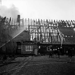 Brand: Wohn- und Wirtschaftsgebäude des Landwirt Kurt Günthersberg: ausgebrannter Dachstuhl: rechts Feuerwehrmänner beim Löschen