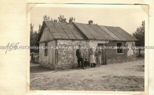 Familie vor einem Haus