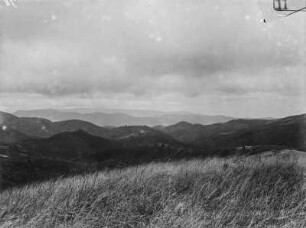 Landschaft : Blick von einer Anhöhe in ein Tal und auf bergige Umgebung