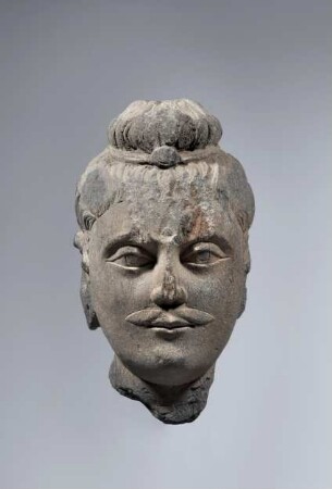 Kopf eines Buddha mit Schnurrbart und Schmuckband um Ushnisha