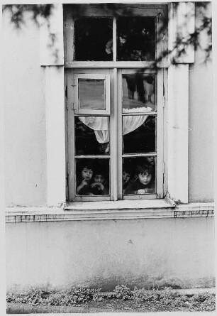 Kinder hinter dem Fenster eines Kindergartens