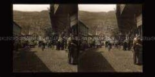 Geschäftstraße mit Passanten und Kutschen, am Ende der Straße Badehaus, Tiflis