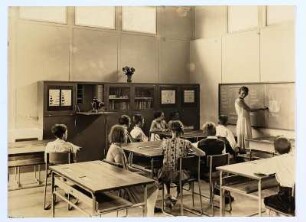 Dresden. Internationale Hygieneausstellung 1930/1931. Entwurf für ein Schulgebäude (Musterschulhaus) (1925/1930). Klassenzimmer. Ansicht mit Lehrerin und Schülern während einer Probeunterrichtsstunde