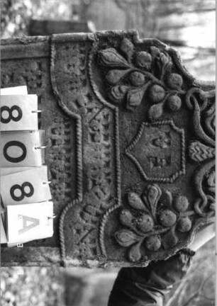 Grabstein 808 (Index: 99751503) Material: Sandstein Zustand: gut Maße HxBxT: 125x56x11 cm Beschreibung: Stele, geschwungen eingezogener Rundbogenabschluß Symbolik: Feigen, Wappenschild, Blätter, Schriftband: Grabstein 808A