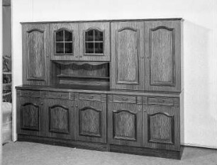 Anbauwand Oberon : Leipzig. Leipziger Herbstmesse (Vormesse), 1986. Anbauwand Oberon. Holz, folienbeschichtet in Eichenholzoptik, rustikal (1986; VEB Meyenburger Möbelwerk)