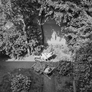 Blick in den Garten mit Frauen im Liegestuhl