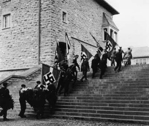 Sonthofen (Kreis Oberallgäu). Gedenkfeier für Ritterkreuzträger Häfele. Fahnen- und Kranzträger auf dem Weg von der Ordensburg zum Denkmal