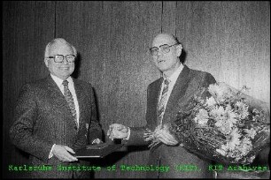 Auszeichnung von Prof. Erwin Willy Becker (Leiter des Instituts für Kernverfahrenstechnik (IKVT)) (links) mit dem Bundesverdienstkreuz durch Prof. Gerhard Seiler (Erster Bürgermeister der Stadt Karlsruhe) (rechts)