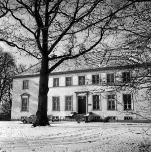 Gut Altfresenburg: das Herrenhaus im Winter: Ansicht der Vorderfront, links ein parkender Pkw
