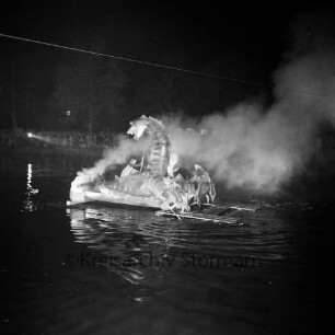 Karpfenfest: Neuhöfer Teich: Nachtaufnahme: Wasserrevue "Der verhexte Karpfenteich": Seeungeheuer, bengalische Feuer, Qualm: Floß als Standfläche und Männer mit Paddel sichtbar: im Hintergrund Zuschauer am Ufer, Scheinwerfer: oben Drahtkabel, 10. Oktober 1965