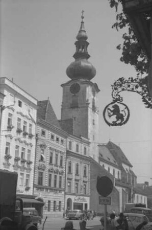 Wels: Stadtpfarrkirche, Vordergrund Aushängeschild [Nasenschild]