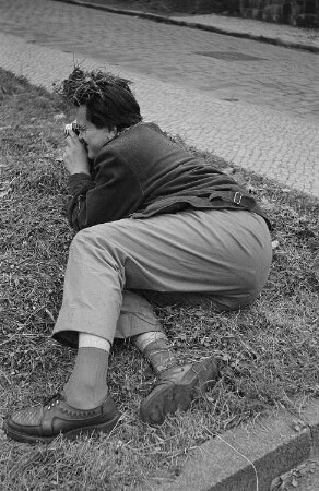 Rudolf Bartsch fotografiert auf einer Wiese liegend