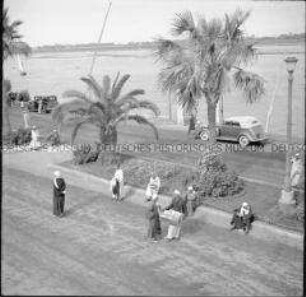 Passanten und Händler auf einer Uferpromenade am Nil, Luxor, Ägypten