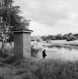 Trave: vorn links Pegelstandshäuschen: dahinter Baum: in der Mitte Angler: hinten Knicklandschaft