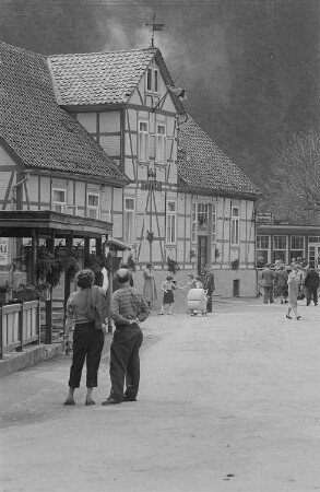 Straßenszene mit Urlaubern im Bodetal, links das Hotel Bodetal