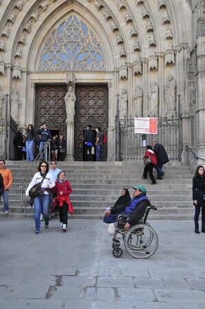 Barcelona - Behinderter im Rollstuhl bettelt : Vor der Kathedrale sitzt ein behinderter Mann in seinem Rollstuhl und bettelt Passanten an. Aufgenommen am 15. April 2012 in Barcelona