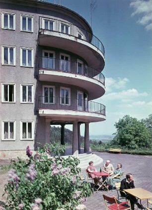 Ferienheim "Fritz Heckert" in Gernrode : Gernrode. FDGB-Ferienheim "Fritz Heckert" (1952-1954; Entwurf des halleschen Ingenieurbüros Maedecke). Eingangsbereich mit Gästen an Gartentischen