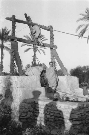 Am Brunnen : Zwei Personen an einem traditionellen Brunnen