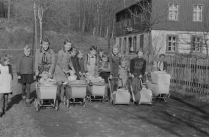 Kinder beim Spielen : Mädchen mit Puppenwagen und Spielzeugpuppen