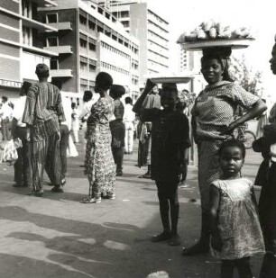 Lagos, Nigeria. Straßenszene im modernen Stadtteil mit Passanten in Festtracht
