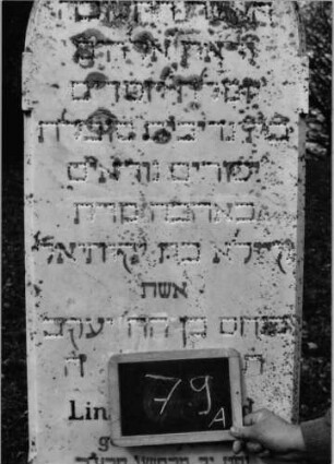 Grabstein 79 (Index: 100090220) Material: weiß. Marmor, Sockel:Granit, Bleibuchstaben Zustand: gut, Buchstab. fast alle beschäd. /entfernt Maße HxBxT: 187x55x17 cm Beschreibung: Stele, Sockel, Rundbogenabschluß: Grabstein 79A