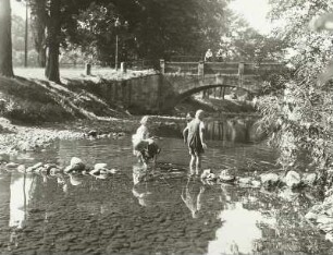 Bahratal. Straßenbrücke über die Bahre mit Damm bauenden Kindern