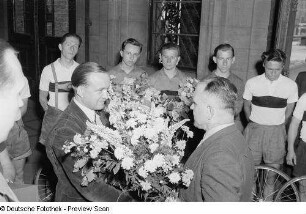 Werner Schiffner während des Überreichens eines Blumenstraußes