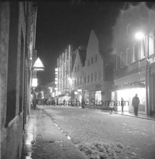 Mühlenstraße: verkaufsoffener Sonnabend mit Fußgängerzone: rechts Einmündung Hindenburgstraße: rechts und links Wohn- und Geschäftshäuser mit Kaufhaus Nickel: dazwischen Fußgänger: Winter: Abend: 8. Dezember 1973