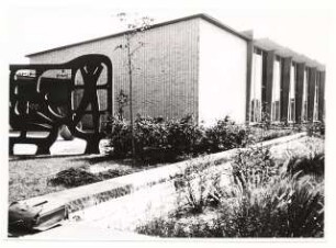 Grünflächen am Max-Planck-Gymnasium, Düsseldorf: Schulgebäude, Sitzmauer und Skulptur