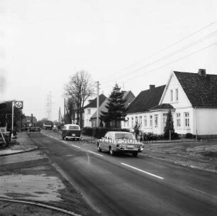 Möllner Landstraße: hinten Mitte Pkw, VW-Bus und Lkw: links Tankstelle: dahinter Baustelle mit Bagger: rechts und hinten Wohnhäuser