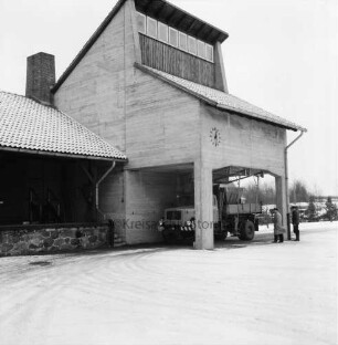 A 1: Bad Oldesloe / Rethwischfeld: Autobahnmeisterei: Betonsilo für Streugut, an Fassade Wanduhr: automatischer Streu-Lkw wird beladen: zwei Männer beim Überwachen des Vorgangs: im Winter
