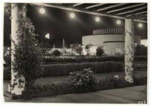 Gartenschau Sommerblumen am Funkturm, Berlin: Blick durch die beleuchtete Pergola auf das Ausstellungsgebäude bei Nacht