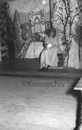 Weihnachtsmärchen: Hotel Oldesloer Hof: Saal: "Aschenputtel": Aufführung von Städtischem Musikkreis: Bühne: Szenenbild mit Schauspielerin: Aschenputtel mit Taube unter Baum: 21. Dezember 1956