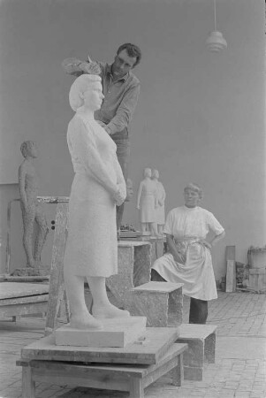 Beim Modellieren einer stehenden Frau mit verschränkten Händen. Gips (1960/1962) (Studentenarbeit der Bildhauerklasse von Walter Arnold)