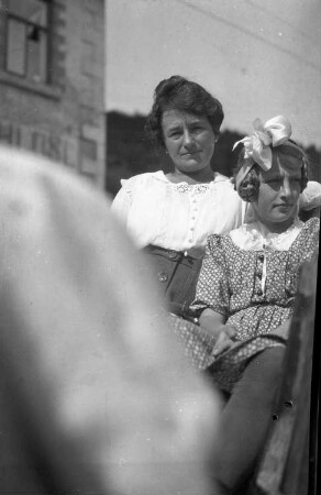 Portrait einer Frau und eines jungen Mädchens, auf dem Rücksitz eines Personenkraftwagens sitzend