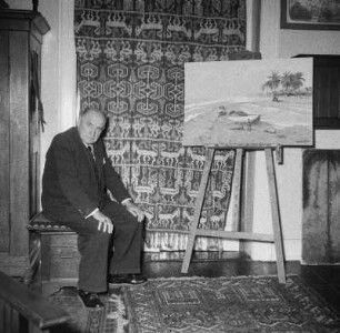 Marburg. Der Maler Prof. Ernst Vollbehr (1876-1960) in seinem Atelier vor einem Gemälde sitzend