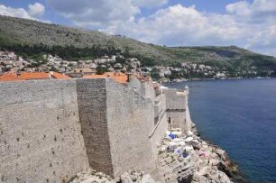 Dubrovnik - Felsen und Stadtmauer : Unterhalb der Stadtmauer sonnen sich Menschen auf den Felsen. Aufgenommen am 2. Juli 2010 in Dubrovnik