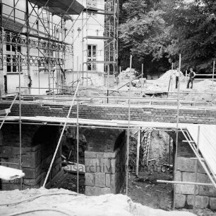 Restaurierung: Brücke vor Eingangsportal: bei Wiederherstellung, mit Gerüst: Seitenansicht: Aufmauern der Gewölbe mit Klinker, Überweg mit Verschalung: Arbeiter: im Vordergrund und Bildmitte hinten zugeschütteter innerer Graben vor Aushebung: Schlossfassade mit Gerüst