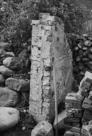 Gut Jersbek: Eiskeller: Restaurierung: Rest Backsteinmauer, dahinter Feldsteinmauer: Feldsteine, Stapel mit Backsteinen
