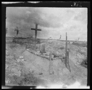 [bei Arras (Dep. Pas-de-Calais, Frankreich):] Soldatengrab [aus französischen Blindgängern erbaut?] beim Schützengraben "Obermay[e]r-Graben" mit Holzkreuz, Pickelhaube und Gewehr
